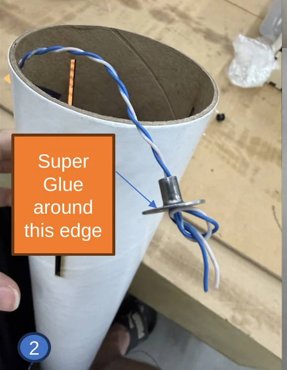 2 — Weld nut on the wire with an overhand knot behind it. The arrow shows the edge the superglue goes around.