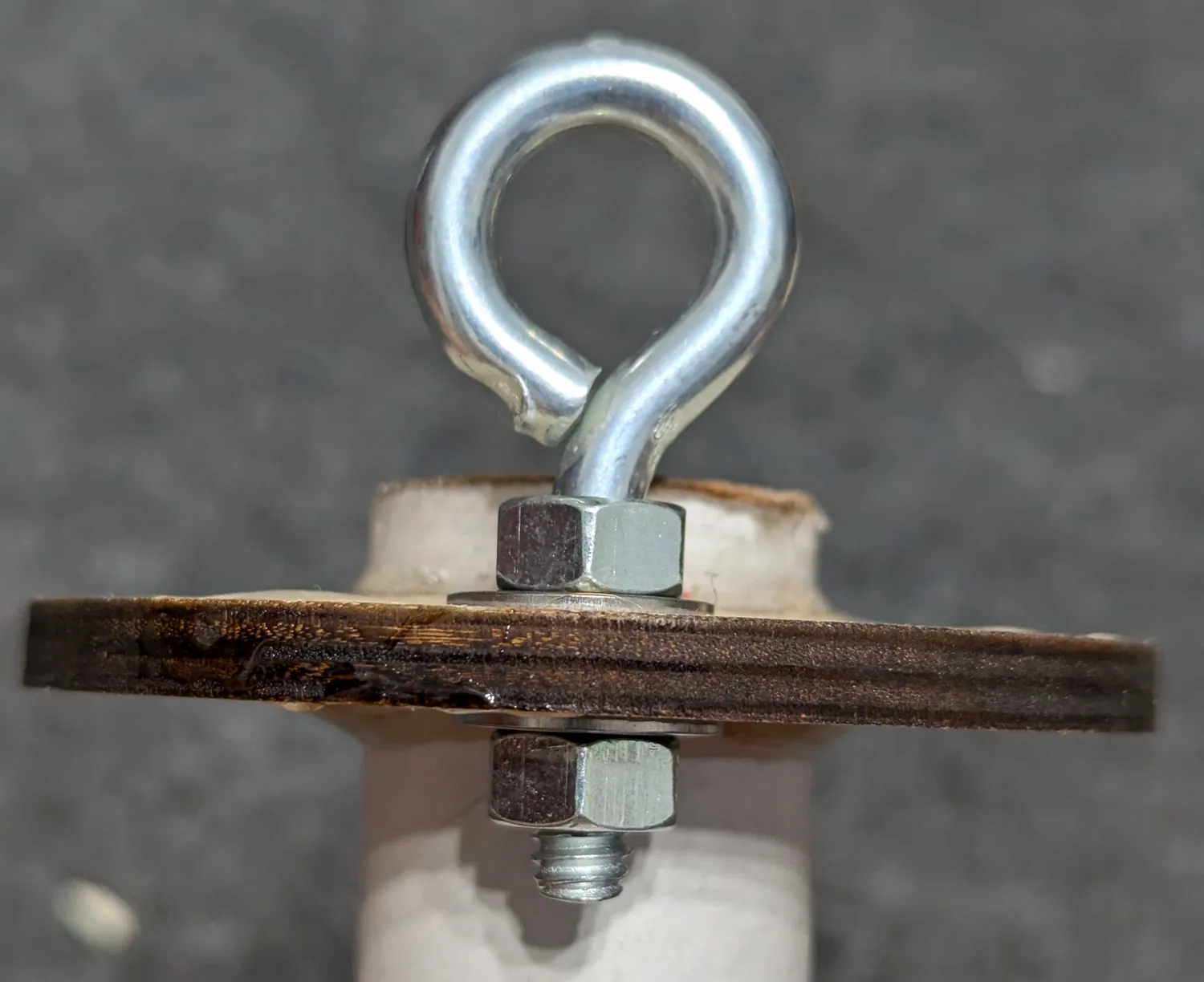 Eyebolt through the ring, washer and nut on both sides.